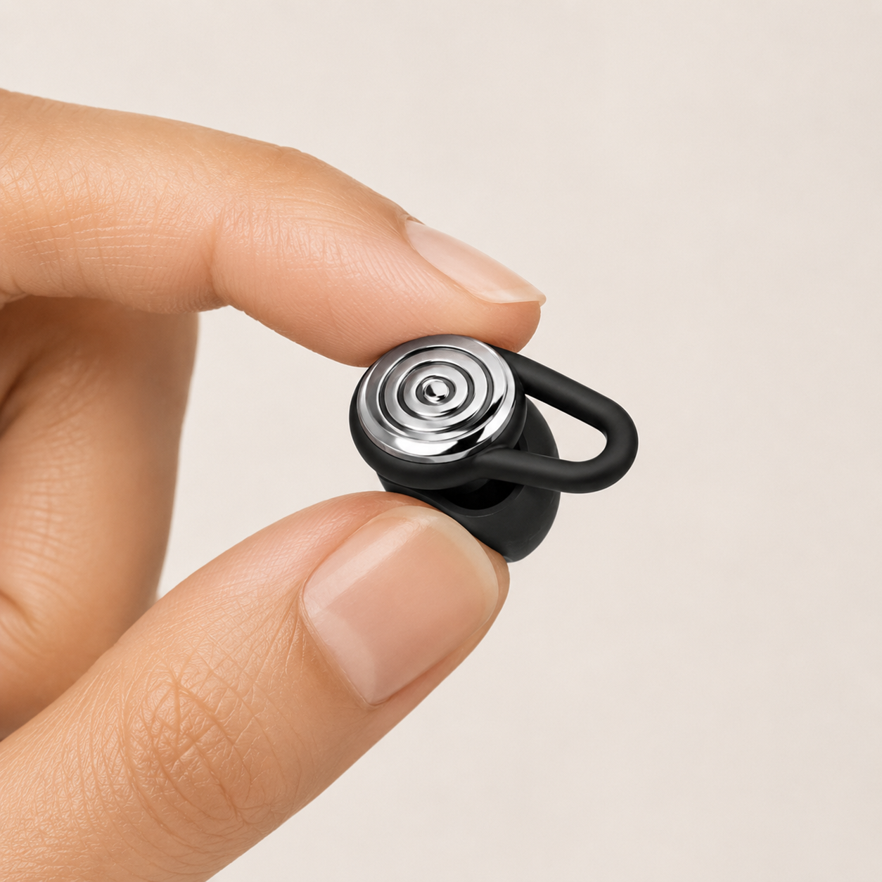 Close-up of a Driftwell earplug held and gently compressed between finger and thumb