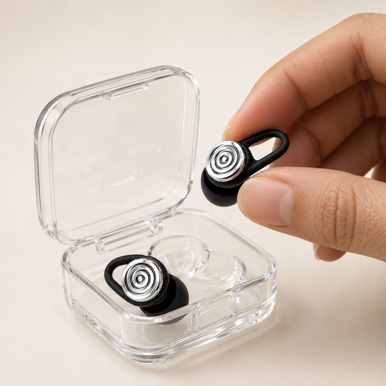 Open clear storage case with a pair of Driftwell earplugs, one lifted out between two fingers